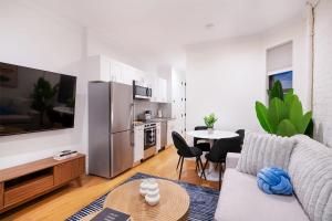 a living room with a couch and a table with chairs at 1290-8 New Renovated 2 Bedrooms in UES in New York