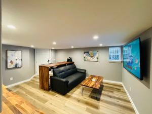 a living room with a black leather couch and a table at Green Lake 1st Line Home C Full Modern Remodeled in Seattle
