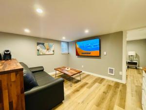 Green Lake 1st Line Home C Full Modern Remodeled في سياتل: غرفة معيشة مع أريكة وتلفزيون على الحائط