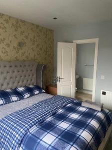a bedroom with a bed with a blue plaid blanket at Private shared room near Blanchardstown shopping center 
