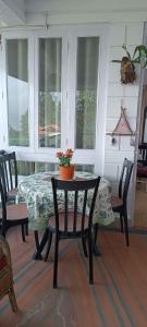 a table and chairs in a room with a table and windows at Mansarover Home Stay in Kalimpong