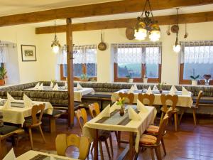 a restaurant with tables and chairs and a couch at Berggasthof Lusen in Neuschönau