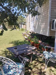 a picnic table and chairs in front of a house at Las Nativas de Areco in San Antonio de Areco