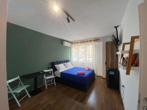 a bedroom with a blue bed and a desk and a chair at What's Up Tirana in Tirana