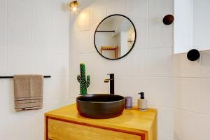 ein Badezimmer mit einem Waschbecken und einem Spiegel in der Unterkunft Bec Rose - Clim - Wi-fi - Jardin in Saint-Leu