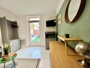 a living room with a table and a mirror at Petit Studio Charmant in Toulon