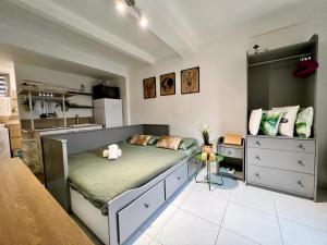 a bedroom with a bed and a kitchen at Petit Studio Charmant in Toulon