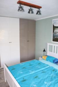 a bedroom with a large bed with blue sheets at Ferienwohnung Am See 55 in Bad Saarow