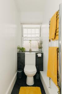 a bathroom with a white toilet and a window at Luxury Private Suite-Parking, Courtyard & Wi-Fi in Caldicot