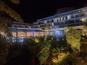 a hotel at night with a garden in front of it at Courtyard Long Beach Apartment in Iskele