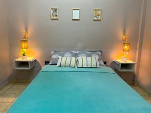 プエルトイグアスにあるSalamのベッドルーム1室(大型ブルーベッド1台、ランプ2つ付)