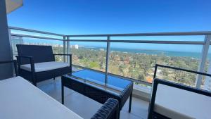 een balkon met stoelen en een tafel en uitzicht op de oceaan bij Torre Bellagio - Hermosa Vista Piso 18 in Punta del Este