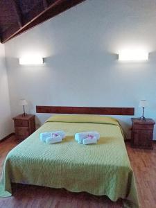 a bedroom with a green bed with two towels on it at Bahia Rooms in El Calafate