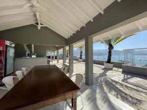 a house with a wooden table and chairs on a patio at DUPLEX MONTECARLO in Ubatuba