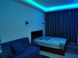 a room with a couch and a bed with blue lights at Cecelia resort in Hurghada