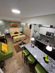 ein Wohnzimmer mit einem Zimmer mit einem Bett und einem Tisch in der Unterkunft Otavalo Suites in Otavalo