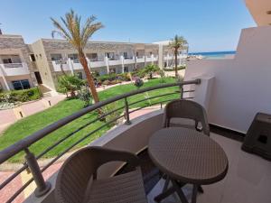 a balcony with a table and chairs and a view of the ocean at Cecelia resort in Hurghada