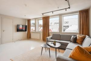 a living room with a couch and a table at Arctic Homes - Premium Penthouse in Tromsø