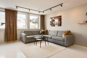 a living room with a couch and a table at Arctic Homes - Premium Penthouse in Tromsø