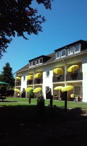 a building with yellow umbrellas in front of it at Gästehaus Falkenhof in Westensee