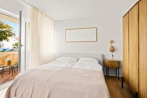 ein weißes Schlafzimmer mit einem Bett und einem Balkon in der Unterkunft Gemütliche Wohnung mit Charme - Smart TV in Gießen