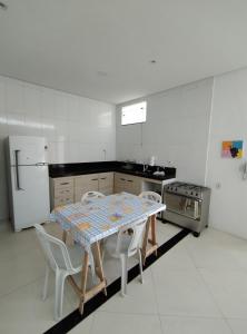 een keuken met een tafel en stoelen en een koelkast bij Apto 3/4 in Serrinha