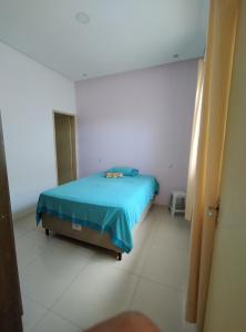 een slaapkamer met een blauw bed in een witte kamer bij Apto 3/4 in Serrinha
