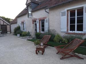 two chairs and a table in front of a house at Agréables chambres d'hôtes dans maison XVIIIe in Vineuil