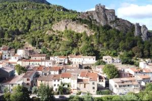 uma cidade em frente a uma montanha com casas em Bienvenue dans notre Gîte de Saint-Roch em Padern