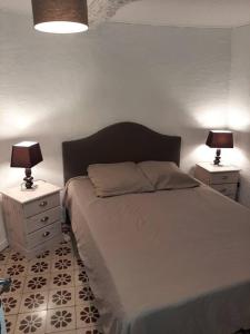 um quarto com uma cama e duas mesas de cabeceira com candeeiros em Bienvenue dans notre Gîte de Saint-Roch em Padern