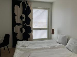 ein Schlafzimmer mit einem weißen Bett und einem Fenster in der Unterkunft Seaside Lux in Turku