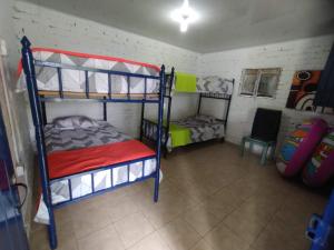 Habitación con 2 literas y 1 silla en FINCA LA COLONIA en Buga