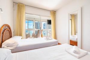 sypialnia z dwoma łóżkami i dużym oknem w obiekcie Niza 11-A Apartment Levante Beach w mieście Benidorm