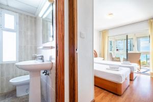 łazienka z umywalką i sypialnia z 2 łóżkami w obiekcie Niza 11-A Apartment Levante Beach w mieście Benidorm