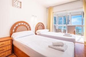 dwa łóżka w pokoju z oknem w obiekcie Niza 11-A Apartment Levante Beach w mieście Benidorm