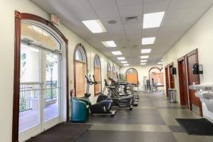 a gym with several treadmills and elliptical machines at Beautiful 4 Bedroom Vacation Home at Regal Palms Resort, close to Disney World in Davenport