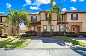 una casa grande con palmeras delante en Beautiful 4 Bedroom Vacation Home at Regal Palms Resort, close to Disney World, en Davenport