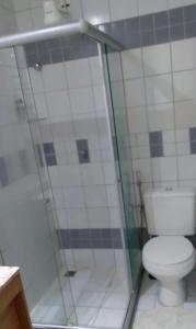 a bathroom with a toilet and a glass shower at Suíte luxo com tela de cinema no América Towers Studio Residence in Salvador