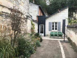 een huis met twee groene banken erbuiten bij La Tranquillité proche Beauval et Châteaux de la Loire in Loches