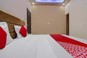 a bedroom with a large bed with red pillows at Hotel Krishna Palace in Jaipur