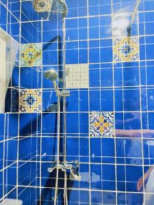 a blue tiled bathroom with a shower at LIMANI in Grigoleti
