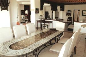 une salle à manger avec une table en verre et des chaises blanches dans l'établissement Lovely Villa Amelkis One Marrakech, à Marrakech