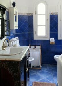 a blue and white bathroom with a sink and a toilet at Lovely Villa Amelkis One Marrakech in Marrakech