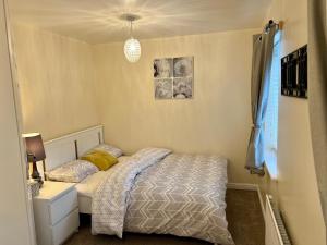 een kleine slaapkamer met een bed en een raam bij Comfort Home in Gillingham