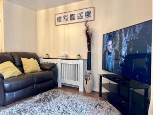 a living room with a couch and a flat screen tv at Comfort Home in Gillingham