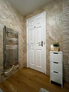 baño con ducha y puerta blanca en Comfort Home, en Gillingham