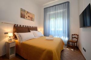 een slaapkamer met een bed, een televisie en een stoel bij La Casa di Ambra in Chianciano Terme