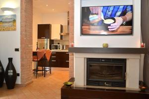 uma sala de estar com lareira e uma televisão por cima em La Casa di Ambra em Chianciano Terme