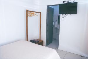 a bedroom with a white bed and a mirror at Hotel Alicia in Fortuna