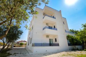 a white building with trees in front of it at Relaxing Escape Rooms in Ksamil